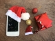 Some Christmas presents and a phone in a Christmas hat.