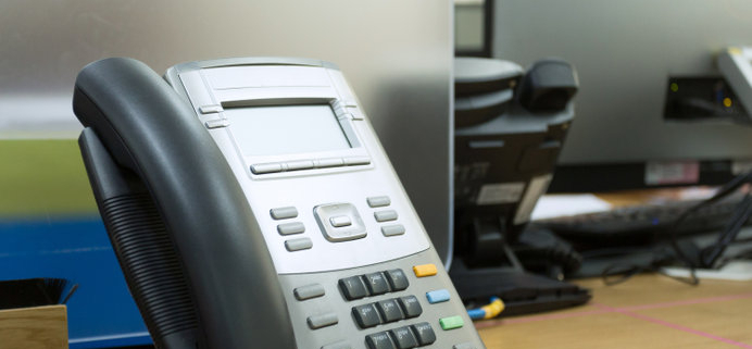 A modern VOIP enabled telephone on a desk.